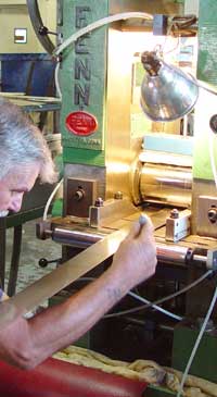 A J.L. Anthony employee applies calipers to a strip of alloy to maintain the highest standard of precision.